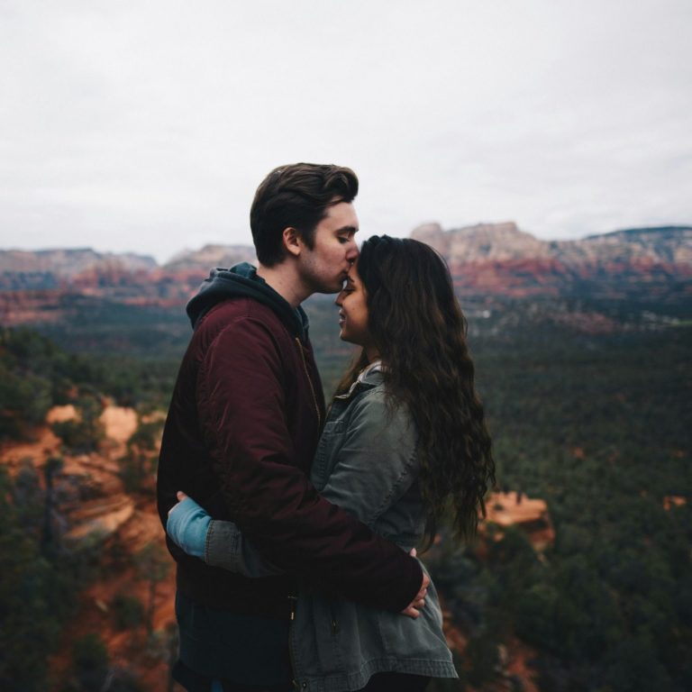 un couple qui s'enlace devant un grand canyon
